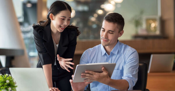 coworkers discuss work laptop tablet